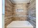 Beautiful wood-look tiled bath and shower with a functional alcove for storage at 12242 Greenwood St, Brooksville, FL 34613