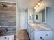 Well-lit bathroom with a large mirror, granite countertop, and a tiled shower with a rainfall showerhead at 12242 Greenwood St, Brooksville, FL 34613