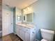 Bathroom with granite countertop, wooden tile flooring and a large framed mirror at 12242 Greenwood St, Brooksville, FL 34613