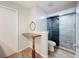 Updated bathroom features elegant glass shower doors, tiled shower, toilet, and wooden table at 12242 Greenwood St, Brooksville, FL 34613
