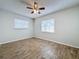 Bedroom featuring wood-look tile flooring, a ceiling fan, and natural light from two windows at 12242 Greenwood St, Brooksville, FL 34613