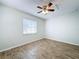 Bedroom with wood-look tile flooring, a ceiling fan, and one window with neutral paint at 12242 Greenwood St, Brooksville, FL 34613