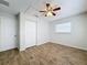 Bedroom showcasing wood-look tile flooring, a ceiling fan, and a double door closet at 12242 Greenwood St, Brooksville, FL 34613