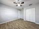 Bedroom with wood-look flooring, ceiling fan, and closet space at 12242 Greenwood St, Brooksville, FL 34613