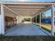 A covered carport area with a workbench, offering ample space for parking and projects at 12242 Greenwood St, Brooksville, FL 34613