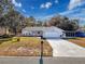 Beautiful home with a two-car garage, a covered carport, and a lush green lawn at 12242 Greenwood St, Brooksville, FL 34613