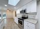 Bright kitchen features stainless appliances, granite counters, and stylish tile backsplash at 12242 Greenwood St, Brooksville, FL 34613