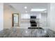 Modern kitchen featuring granite countertops, stainless steel appliances, and a view into the dining area at 12242 Greenwood St, Brooksville, FL 34613