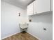 Functional laundry area with a utility sink and wall-mounted cabinets at 12242 Greenwood St, Brooksville, FL 34613