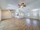 Open living room with wood-look tile flooring, ceiling fans, and kitchen access at 12242 Greenwood St, Brooksville, FL 34613