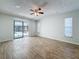 Spacious living room with neutral paint, ceiling fan, and sliding glass doors leading to the lanai at 12242 Greenwood St, Brooksville, FL 34613
