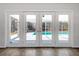 Patio doors view features a screened-in pool area and lush landscaping at 12242 Greenwood St, Brooksville, FL 34613