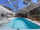 Enclosed pool boasts sparkling water, lush yard views, and seamless access to the home's living area at 12242 Greenwood St, Brooksville, FL 34613