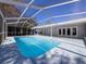 Screen-enclosed pool boasts sparkling blue water and access to the home, creating a seamless indoor-outdoor living experience at 12242 Greenwood St, Brooksville, FL 34613