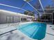 A serene pool is enclosed within a screened-in structure with seamless access to the home for easy indoor/outdoor living at 12242 Greenwood St, Brooksville, FL 34613