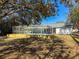 Rear view of house with a screened in pool, and wooden patio, offering serene outdoor enjoyment at 12242 Greenwood St, Brooksville, FL 34613