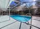 Sparkling blue water graces the enclosed backyard pool that features landscaping views and convenient access to outdoor lounging at 12242 Greenwood St, Brooksville, FL 34613