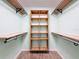 Functional walk-in closet with built-in wooden shelving and rods for optimal storage at 12242 Greenwood St, Brooksville, FL 34613