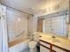 Bright bathroom with a shower over tub, vanity, and a large mirror at 13103 Cypress Hill Dr # B2, Hudson, FL 34669