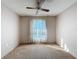 Bright bedroom with neutral carpet, ceiling fan, and sheer curtained window at 13103 Cypress Hill Dr # B2, Hudson, FL 34669