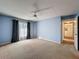 Bedroom featuring carpet, a ceiling fan, a window with curtains, and light blue walls at 13103 Cypress Hill Dr # B2, Hudson, FL 34669