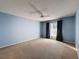 Spacious bedroom with carpet, a ceiling fan, a window with curtains, and light blue walls at 13103 Cypress Hill Dr # B2, Hudson, FL 34669