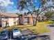 Well-maintained building exterior with lush landscaping, parking, and clear blue sky at 13103 Cypress Hill Dr # B2, Hudson, FL 34669