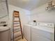 Efficient laundry room with modern washer and dryer, and extra shelving space for storage at 13103 Cypress Hill Dr # B2, Hudson, FL 34669