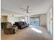 Living room with mirrored wall, ceiling fan, comfortable seating, and access to a screened balcony at 13103 Cypress Hill Dr # B2, Hudson, FL 34669
