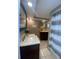 Modern bathroom featuring dual vanities and a tub with a shower, well lit with spotlights overhead at 1817 Dartmouth Dr, Holiday, FL 34691