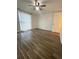An empty bedroom featuring modern hardwood floors, a ceiling fan, and a large sunny window at 1817 Dartmouth Dr, Holiday, FL 34691