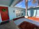 Charming home with a red front door, palm tree, and blue exterior paint at 1817 Dartmouth Dr, Holiday, FL 34691