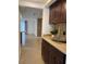 View of the kitchen featuring tile floors, dark wood cabinets, and plenty of natural light at 1817 Dartmouth Dr, Holiday, FL 34691