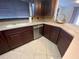 Kitchen featuring dark wood cabinets, stainless steel dishwasher, and light countertops at 1817 Dartmouth Dr, Holiday, FL 34691