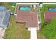 Aerial view showcases the well-maintained property with a pool, fenced yard, and neatly kept landscaping at 2013 Meredith Dr, Spring Hill, FL 34608