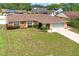 Charming single-story home featuring a stone accent wall, arched entryway, and a well-maintained lawn at 2013 Meredith Dr, Spring Hill, FL 34608