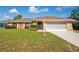 Beige ranch-style home with a stone accent wall, mature landscaping, and screen garage at 2013 Meredith Dr, Spring Hill, FL 34608