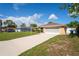 Charming single-story home featuring a well-maintained lawn and a long driveway on a sunny day at 2013 Meredith Dr, Spring Hill, FL 34608