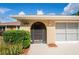 Close-up on beige-walled front porch, dark wood front door, side bushes and the house number at 2013 Meredith Dr, Spring Hill, FL 34608