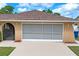 Beige exterior of house including enclosed garage door plus side entry at 2013 Meredith Dr, Spring Hill, FL 34608