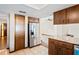 Kitchen featuring stainless steel refrigerator, tile floors, wooden cabinets, and a view into the living area at 2013 Meredith Dr, Spring Hill, FL 34608