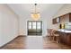 Open-concept kitchen and dining area with laminate floors, stylish lighting, and a view of the lanai at 2013 Meredith Dr, Spring Hill, FL 34608