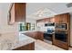 Updated kitchen with granite countertops, stainless steel appliances, wooden cabinets, and tile flooring at 2013 Meredith Dr, Spring Hill, FL 34608