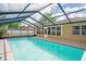 Large screened-in pool with clear water and surrounding patio area, perfect for outdoor enjoyment and relaxation at 2013 Meredith Dr, Spring Hill, FL 34608