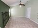 Light and airy bedroom features a ceiling fan, tile floor, and neutral light green walls at 355 Royal Palm Way, Spring Hill, FL 34608