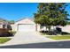 Charming home featuring a two-car garage, a well-maintained lawn, and a mature shade tree at 355 Royal Palm Way, Spring Hill, FL 34608