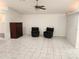 Large living room with tile floors, ceiling fan, and two black cushioned chairs at 355 Royal Palm Way, Spring Hill, FL 34608