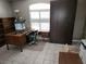 Office space with tile flooring, a built-in bookshelf, a large desk, and a bright window for natural light at 355 Royal Palm Way, Spring Hill, FL 34608