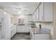 Well-lit kitchen features white cabinets, granite countertops, stainless steel appliances, and a modern ceiling fan at 3736 Sail Dr, New Port Richey, FL 34652
