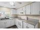 Bright kitchen features white cabinets, granite countertops, stainless steel appliances, and a modern ceiling fan at 3736 Sail Dr, New Port Richey, FL 34652